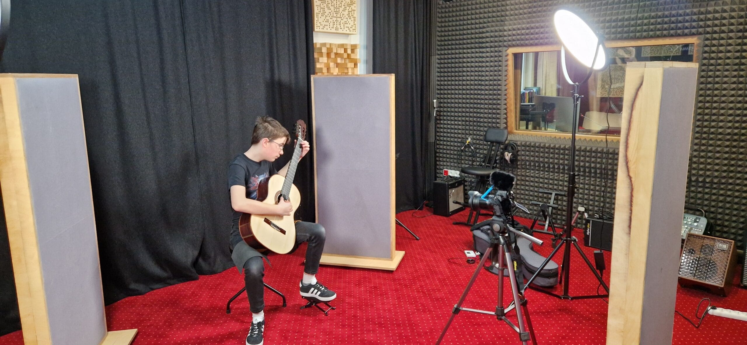 Muzyk grający na gitarze akustycznej w profesjonalnym studiu nagrań